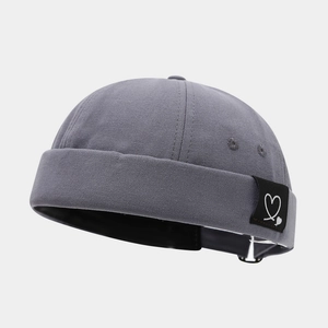 Detail of grey Miki hat featuring heart patch and adjustable metal buckle strap