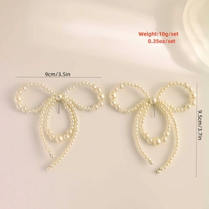 Detailed view of oversized pearl bow earrings with size and weight measurements