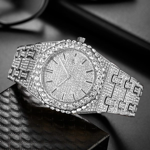 Detailed macro view of iced-out silver men watch with calendar display and crystals