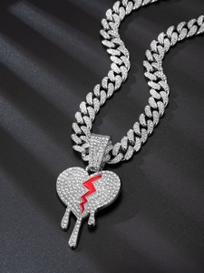 Macro shot of silver Cuban link chain with rhinestone heart pendant and red flash design