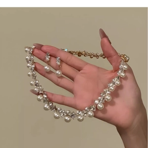 Detailaufnahme der diamantbesetzten Rauten-Perlenohrringe und Halskette im Schmuckset