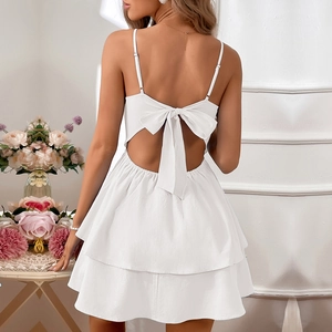 Detailed back view of white cotton mini dress showing an oversized bow and layered cake skirt