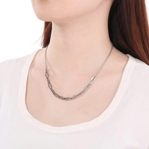 Detailed close-up of a modern silver stainless steel geometric link necklace on a model