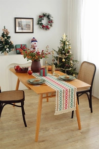 Detailed weave of red and green cotton linen table runner with tassels for Christmas