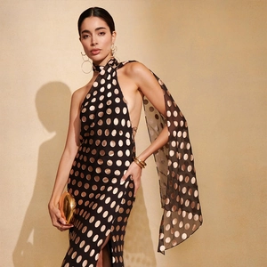 Dettaglio dell'elegante abito all'americana a pois neri e oro con profonda schiena nuda