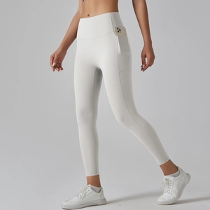 Close-up of white high-waisted yoga leggings with side pocket holding a mobile phone