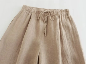 Detail der hoch taillierten Baumwoll-Leinen-Hose mit Kordelzug in Beige mit weitem Bein
