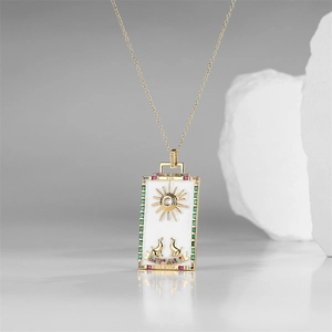 Macro detail of gold tarot pendant with white enamel The Moon design and gems