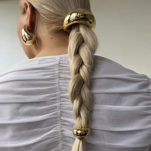 Close-up of golden dual-layer elastic hair rings and matching earrings set on a model