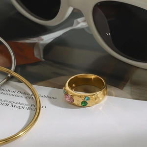 Detail of wide gold textured ring with multicolored round zircons on a fashion magazine
