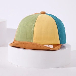 Close-up of a colorful patchwork cotton baby baseball cap with soft orange brim detail