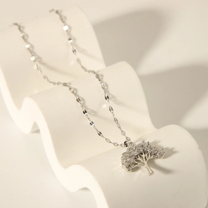 Macro detail of silver Tree of Life pendant with sparkling zircons on elegant metal chain