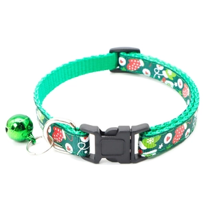 Detail of green Christmas pet collar with snowman prints, safety buckle, and jingle bell