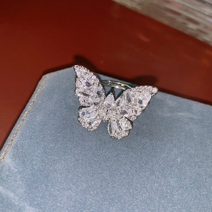 Gros plan d'une bague papillon en argent avec zircons brillants dans un écrin bleu