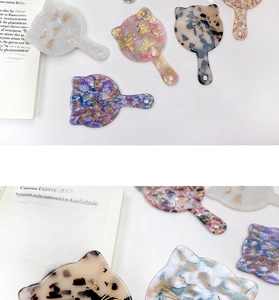 Detail of cat-shaped acetate hand mirrors with elegant marble textures and pastel colors