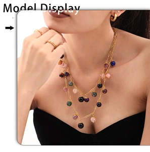 Detailed view of layered gold chain necklace with colorful natural stone charms on model