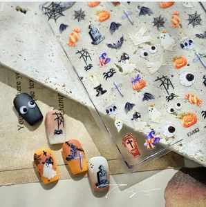 Detailed view of Halloween nail art stickers featuring ghosts and pumpkins on stone surface