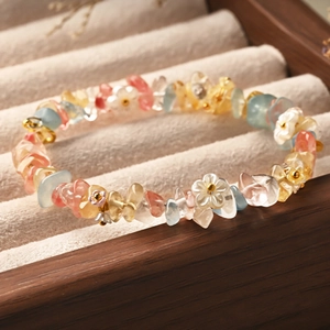 Macro shot of colorful crystal chip bracelet with shell flower charms on a velvet tray