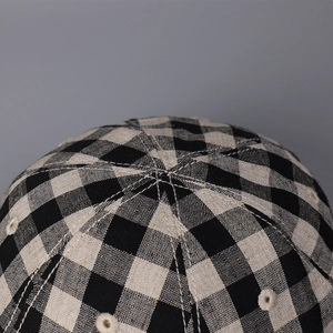 Detail shot of a plaid linen baseball cap showing stitching and breathable eyelets