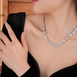 Detailed close-up of a silver necklace with sparkling teardrop and marquise zircons