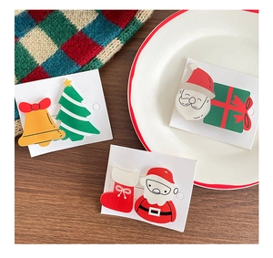 Close-up of cute Christmas hair clips with Santa and tree motifs on a display card