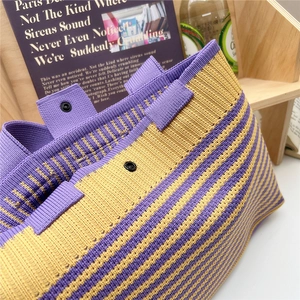 Macro detail of purple and yellow striped knit tote bag with durable metal snap button closure