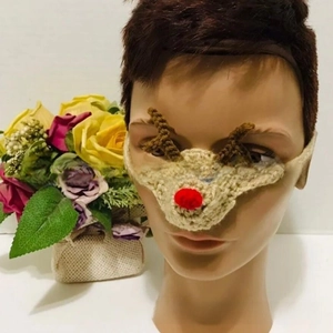 Detailed view of hand-knitted reindeer nose warmer with festive red pom-pom and brown antlers
