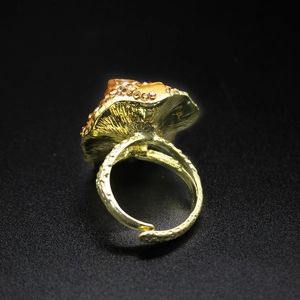 Detailed close-up of a vintage gold mushroom ring with amber stone and brown crystals
