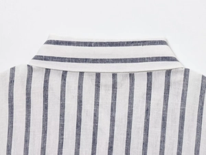 Dettaglio del colletto e della spalla di una camicia di lino a righe bianche e blu