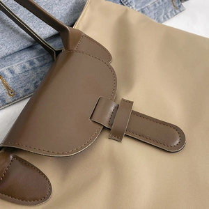 Khaki large capacity nylon tote bag with brown leather handles and premium stitching detail