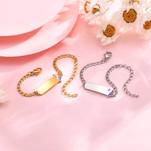 Detail of gold and silver steel curb bracelets with colorful unicorn charm on pink background