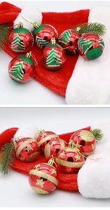 Detail of 6cm red Christmas baubles with hand-painted green trees and gold stars patterns