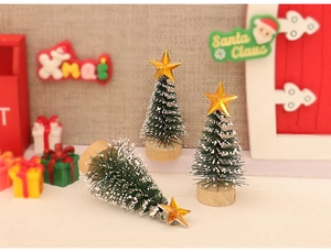 Close-up of mini snow-flocked Christmas trees with gold star toppers and wooden bases