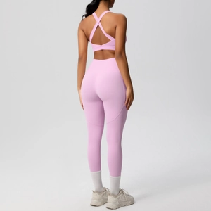 Vista posteriore di un set yoga rosa con reggiseno sportivo incrociato e leggings a vita alta
