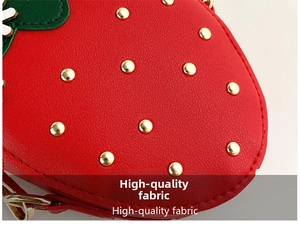 Close-up of strawberry purse showing red textured PU leather and golden stud details