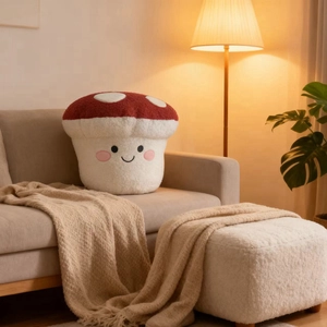 Close-up of soft red mushroom plush pillow with embroidered smile in a cozy living room
