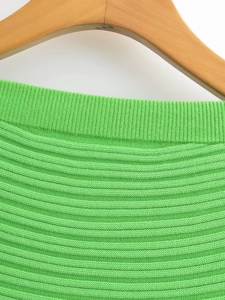 Close-up of green knitted dress texture showing ribbed neckline and horizontal patterns