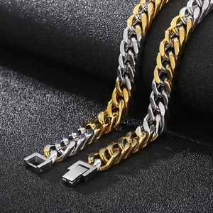 Two-tone gold and silver Cuban link chains with square box clasps on black texture