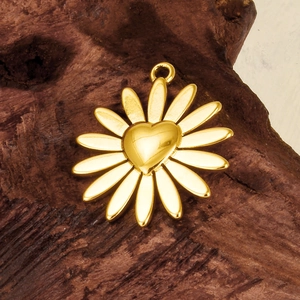 Detailed view of a gold 304 stainless steel daisy pendant with a heart center on wood