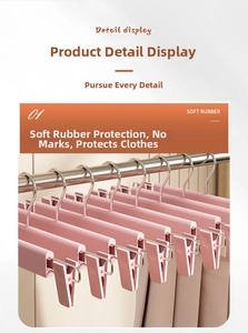 Close-up of pink non-slip pants hangers with adjustable clips on a metal wardrobe rod