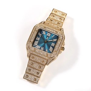 Macro detail of the iced-out gold square watch face with blue dial and Roman numerals