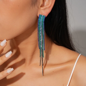 Detail of long fringe earrings with blue and green rhinestones on elegant model