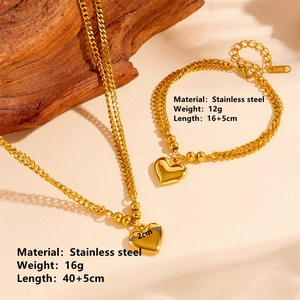 Dettaglio del set collana e bracciale a cuore in acciaio inossidabile dorato con marchio