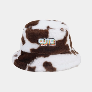 Détail de la fourrure synthétique douce et patch brodé CUTE sur le bob motif vache