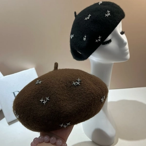 Detail view of starry rhinestone beret with silver star patterns on warm wool fabric