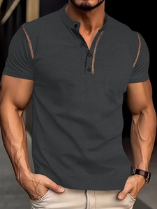 Detailed close-up of charcoal waffle knit polo shirt with contrasting brown button placket