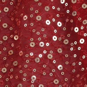 Detailed macro view of luxury red mesh fabric with shimmering hand-beaded silver sequins