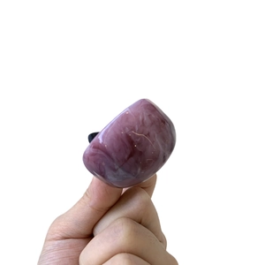Elegant purple resin ring with marble texture shown on fingers against white background