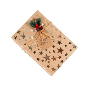 Brown kraft gift wrapping paper with gold star foil, hemp rope and pine needle decor