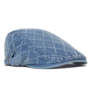 Detailed macro view of quilted denim ivy cap with frayed edges and copper buckle